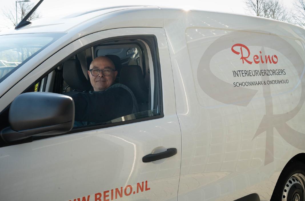 Reino medewerker in een witte Reino bestelbus