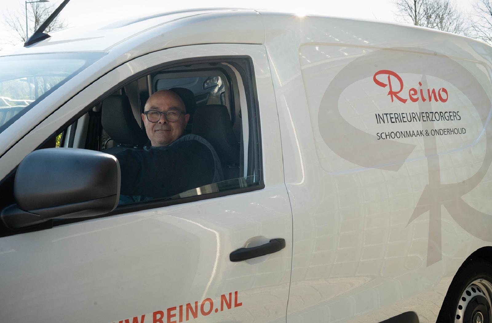 Reino medewerker in een witte Reino bestelbus