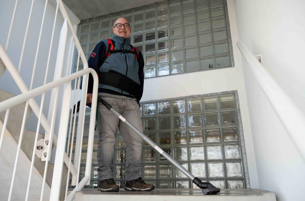 Reino medewerker met rugzak stofzuiger op een trap