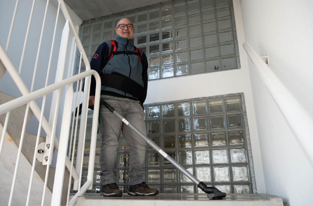 Reino medewerker met rugzak stofzuiger op een trap