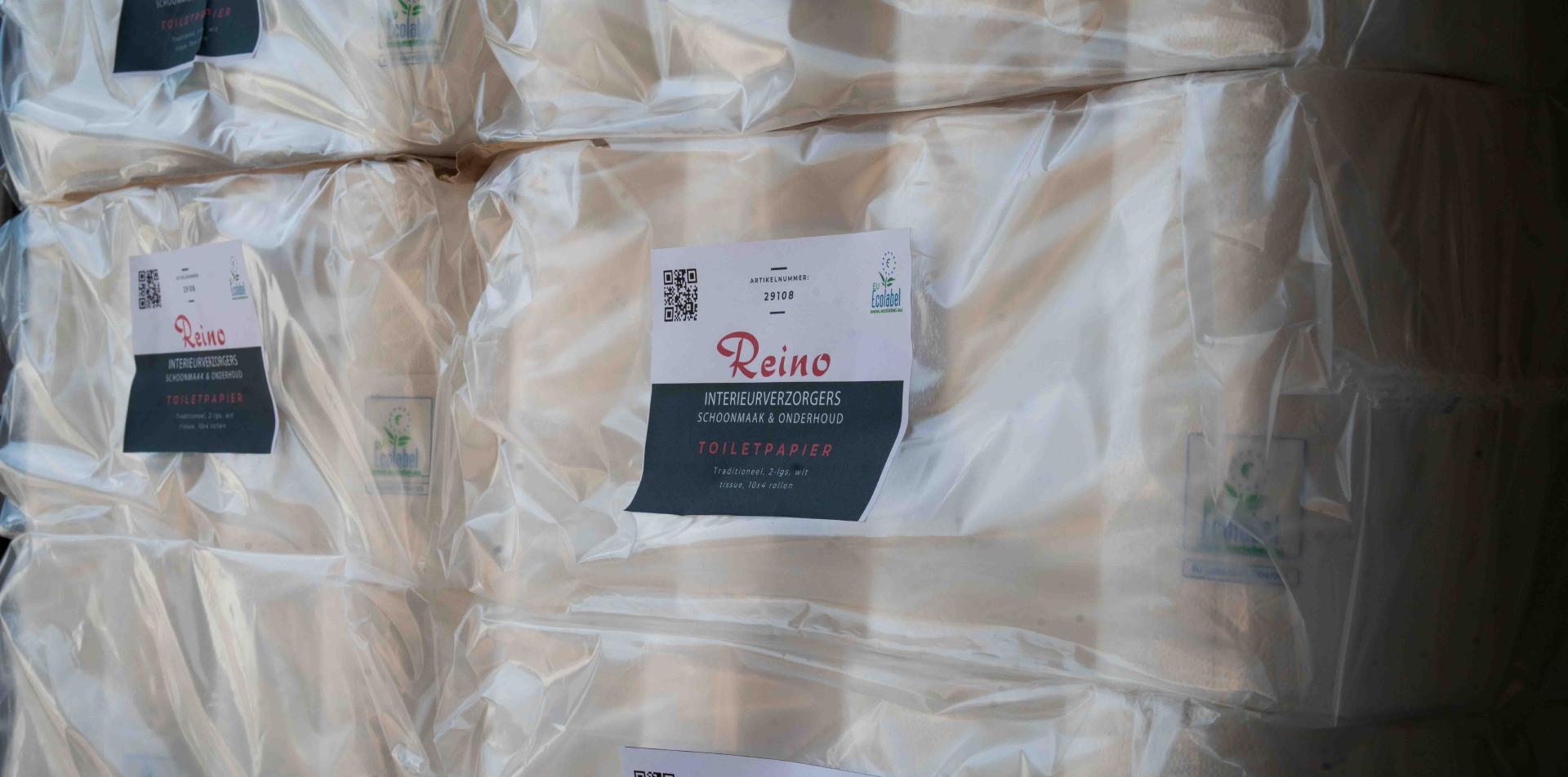 Gestapelde pakken Reino toiletpapier met Reino logo en EU Ecolabel