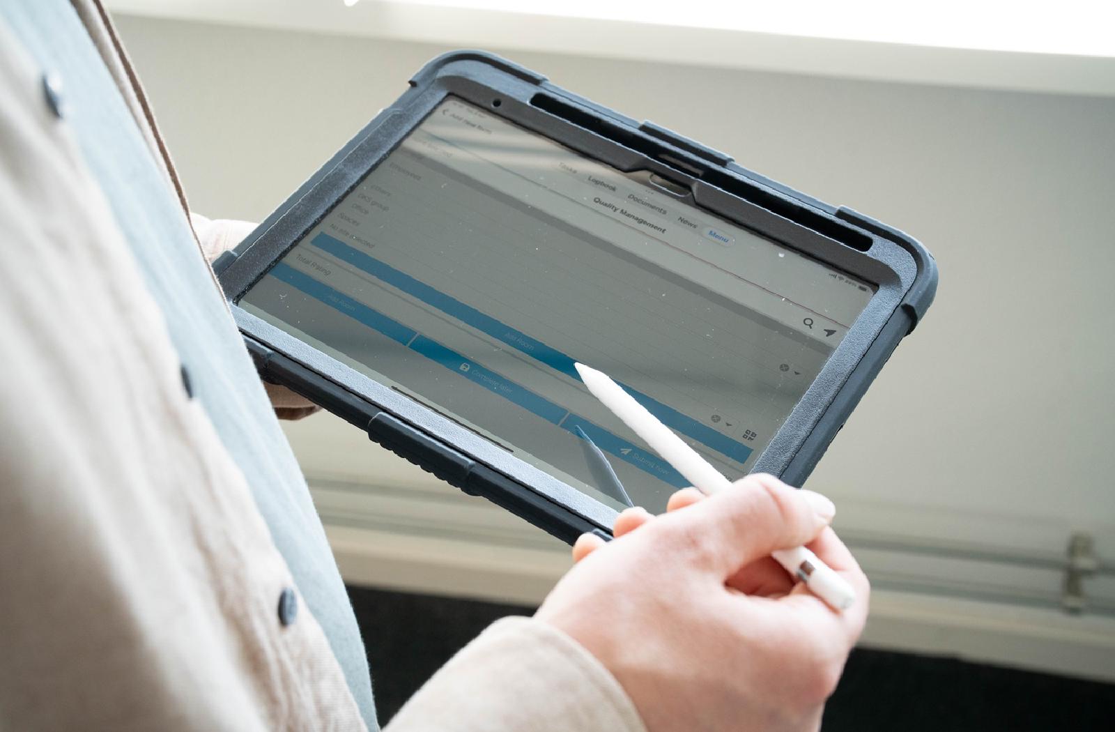 Medewerker houdt tablet met Appreo kwaliteitsbeheersoftware vast