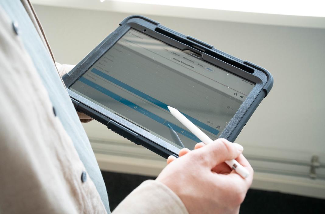 Medewerker houdt tablet met Appreo kwaliteitsbeheersoftware vast