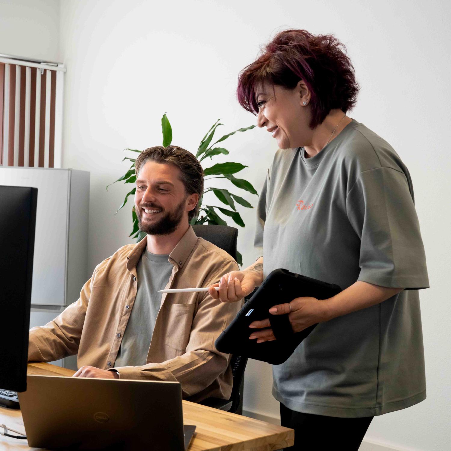 Yannick Nieuwenhoven overlegt met een medewerker achter een laptop op kantoor