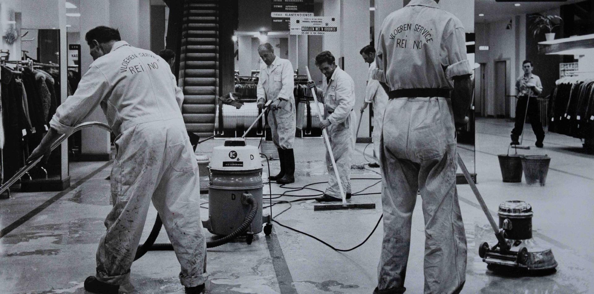 Historische zwart-witfoto van Reino medewerkers die een warenhuis schoonmaken, jaren vijftig